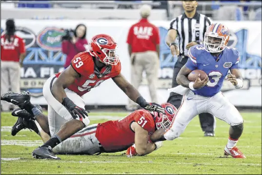  ?? JOHN RAOUX / AP ?? Georgia veteran linebacker Jordan Jenkins (59), backing up Jake Ganus in stopping Florida quarterbac­k Treon Harris for a loss, has had an uncharacte­ristic and frustratin­g season trying to play through a persistent muscle strain near his groin.