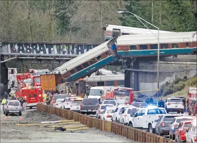  ?? AP PHOTO ?? Cars from an Amtrak train lay spilled onto Interstate 5 below as some remain on the tracks above Monday, Dec. 18, 2017, in DuPont, Wash.