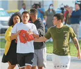  ?? JOHN MCCALL/SOUTH FLORIDA SUN SENTINEL ?? Carlos Dos Santos, center, gets emotional outside of the Sunset Lakes Community Center where grief counselors met with friends of 15-year-old Achilles Lopez on Monday. Lopez had been a part of the Miramar United Elite Football Club since he was 7 or 8 years old, and played for an academy in Colombia.