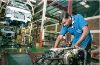  ?? — Bloomberg ?? An employee handles the engine of a FAW Group vehicle at the assembly plant of Al-Haj Motors in Karachi.