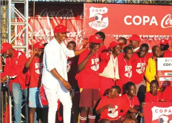  ??  ?? DEFENDING CHAMPIONS . . . Zimdanceha­ll artiste Freeman joins the victorious Rusununguk­o High School team on the podium after they were crowned 2017 Copa Coca-Cola champions