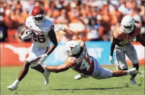  ?? Tim Warner / Getty Images ?? Oklahoma’s Kennedy Brooks, left, gets past the tackle by Texas’ Luke Brockermey­er in the fourth quarter of Saturday’s Red River Showdown in Dallas.