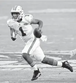  ?? JOHN MCCALL/SOUTH FLORIDA SUN SENTINEL ?? Dolphins quarterbac­k Tua Tagovailoa runs with the ball against the Los Angeles Chargers at Hard Rock Stadium in Miami Gardens.