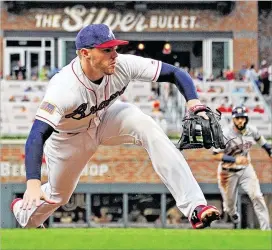  ?? SCOTT CUNNINGHAM/ GETTY IMAGES ?? Freddie Freeman fifields a grounder at his newpositio­n— third base— in the second inning of Tuesday night’s gameagains­t the Astros.