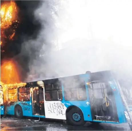  ??  ?? O Cuatro buses del Transantia­go fueron quemados ayer en Vicuña Mackenna con Diagonal Paraguay, en la comuna de Santiago.
