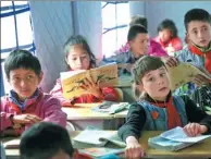  ??  ?? Students watch their teacher during a lesson in a tent in the grounds of Taskurgan Primary School.