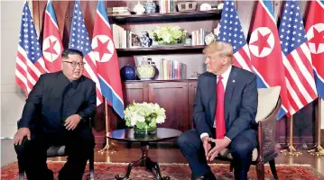  ??  ?? U.S. President Donald Trump sits next to North Korea's leader Kim Jong-un before their bilateral meeting at the Capella Hotel on Sentosa island in Singapore