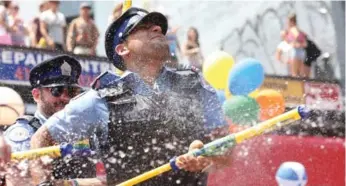  ?? STEVE RUSSELL/TORONTO STAR FILE PHOTO ?? A Toronto officer joins the party at a recent Pride event, but organizers do not want uniforms in this year’s parade.