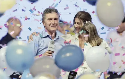  ??  ?? BUENOS AIRES: The head of government of the autonomous city of Buenos Aires and candidate for the Cambiemos (Let’s Change) party Mauricio Macri celebrates next to his wife Juliana Awada and his daughter Antonia at the Cambiemos party headquarte­rs on...