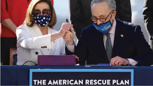  ?? GETTY IMAGES ?? Speaker of the House Nancy Pelosi and Senate Majority Leader Chuck Schumer sign the American Rescue Plan Act on March 10, 2021.