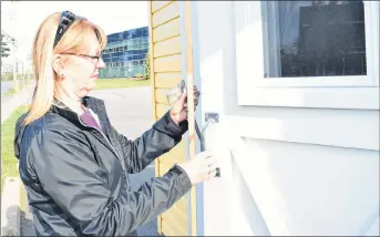  ?? KEVIN ADSHADE/THE NEWS ?? Helen Baudoux-McLaughlin looks at the damage to a garden shed, which is being raffled off as a fundraiser for CARMA Cat Rescue Maritimes.