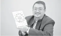  ??  ?? Amirudin showing the book of the True Story of Cyber 999. - Bernama photo