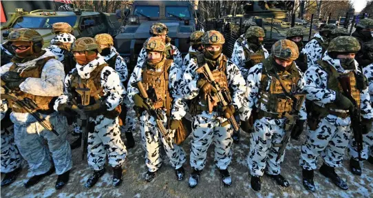  ?? ?? Top: Ukrainian soldiers gear up for training in the ghost town of Pripyat.