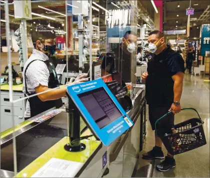  ?? PHOTOS BY JACQUELINE RAMSEYER ?? The first customer at the new Whole Foods in downtown Sunnyvale is seen at a check stand inside the store, which opened on Oct. 29.