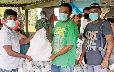  ?? Photo: Salote Qalubau ?? From left: JPT Enterprise Director Moutasim Akash hands over a food pack to Sitiveni Namure and Vunato Settlement headman Jone Rabici (far right).