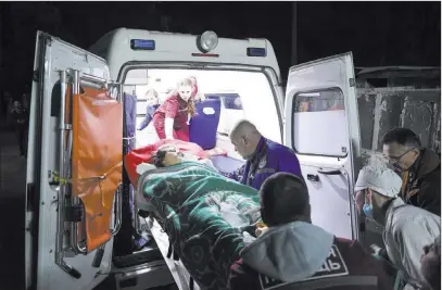  ??  ?? The Associated Press Medics load an injured person onto an ambulance Wednesday in Kerch, Crimea. Russian officials say an 18-year-old student attacked his vocational school in Crimea, killing 19 people and wounding more than 50 before killing himself.