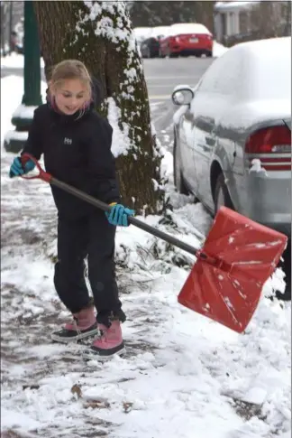  ?? PETE BANNAN - MEDIANEWS GROUP ?? Caroline Travis, 10, clears snow from the sidewalk of her parents’ West Chester home Monday morning. Her school was closed for the day so she was making money shoveling then heading out for some sledding in the afternoon.