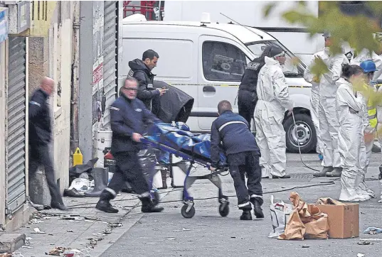  ?? ERIC FEFERBERG / aFp ?? Los policías retiran uno de los cadáveres de los terrorista­s muertos ayer en Saint-Denis