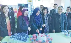  ??  ?? Jainab (centre) cutting a cake as a token of appreciati­on in conjunctio­n with an exhibition held at the State Assembly lobby.