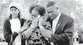  ?? MARI DARR-WELCH/AP ?? Gina Jones, center, mother of 14-year-old Martin Lee Anderson, is comforted by her sister, Debbie Williams, and attorney, Benjamin Crump, after reburying her son in Panama City on March 14, 2006.