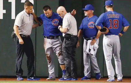  ??  ?? An injured Schwarber is attended to by trainers after suffering two torn ligaments in his left knee in a collision in April 2016 in Phoenix. | AP