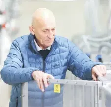  ?? ?? David Pacheco, principal scientist at AgResearch, looking at a calf in a holding cell where it is having its gas emissions monitored at the New Zealand Agricultur­al Greenhouse Gas Research Centre.