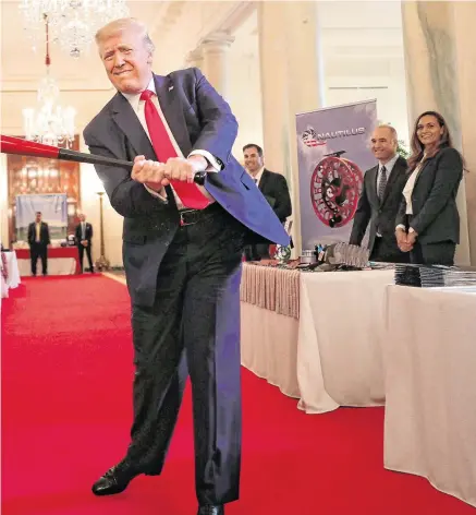  ?? PHOTO: GETTY ?? Come out swinging: Donald Trump holds a baseball bat while looking at exhibits during a Spirit of America showcase at White House.