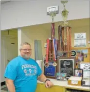  ??  ?? Steve “CP” Pattison, coach of the Pennridge High School powerlifti­ng team, stands with several of the awards, medals and trophies he has won.