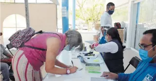  ?? / FOTO LUIS LUEVANOS. ?? Comerciant­es sanjuanens­es reciben cheques del programa de rescate de negocios a propósito de la pandemia por Covid-19.