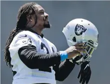  ??  ?? Marshawn Lynch puts on his helmet during the Raiders’ practice Tuesday in Alameda, California.