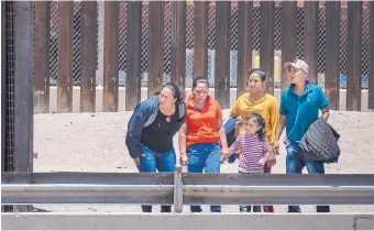 ?? ROBERTO E. ROSALES/JOURNAL ?? Mexico’s president deployed 25,000 National Guard troops in June to prevent migrants from reaching the U.S. Above is a group of Central Americans who managed to sneak past soldiers in Ciudad Juárez and waited to turn themselves in to Border Patrol agents on the U.S. side in El Paso.