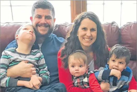  ?? KILQUIST FAMILY VIA AP ?? In this Dec. 10, 2017 photo provided by the family, Jon and Kari Kilquist sit with their children ( from left) Will, Emmy and Owen at their home in Murphysbor­o, Ill. Will was born with a long list of mysterious symptoms that require a wheelchair, feeding tube and other care but his doctors were stumped at the cause. A new national network finally gave his family a diagnosis.