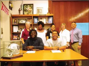  ?? Photo by Ernest A. Brown ?? Shea senior football players Gladior Kwesiah (seated, left) and Yanique Duarte (seated, right) signed their National Letters of Intent to play football at AIC next season. The duo was joined by (back row, left to right) Shea director of athletics Kate...