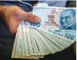  ?? — AFP ?? A change office staff shows Turkish lira in his hand in Istanbul.