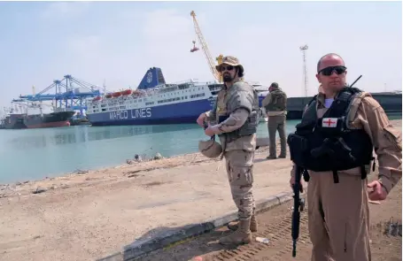  ??  ?? Photo ci-dessus : Le 26 avril 2008, à Umm Qasr, en Irak, un membre de la SMP britanniqu­e Aegis protège des « contractor­s » américains supervisan­t la livraison de véhicules pour les forces irakiennes. Si l’Irak et l’Afghanista­n ont représenté des marchés particuliè­rement juteux pour les sociétés militaires privés, ces dernières sont présentes dans de nombreux pays. (© AFP/Essam Al-Sudani)