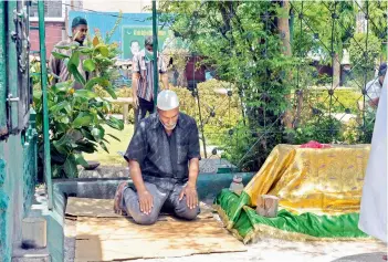  ?? — P. SURENDRA ?? With mosques being closed on the Jumat-ul-vida (last Friday of Ramzan) due to the ongoing nationwide lockdown, a devotee offers prayer in front of the Mahboob Chowk mosque near Charminar.