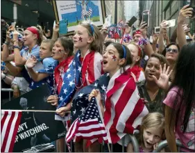  ?? CRAIG RUTTLE — THE ASSOCIATED PRESS ?? Fans celebrate as members of the U.S. women’s soccer team pass by during a ticker tape parade along the Canyon of Heroes on Wednesday in New York.