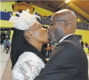  ??  ?? Delgardo Black (right) greets his wife Windy with a kiss after he was ordained as a pastor of the Seventh-day Adventist Church during the service of ordination.