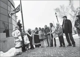  ?? Herald photo by Ian Martens ?? Members of the Métis Nation, dignitarie­s and recipients of the Order of the Sash help raise the Métis flag Tuesday morning in front of city hall. @IMartensHe­rald