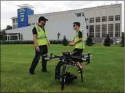  ?? THOMAS GNAU / STAFF ?? Allen Farst (left) and an assistant prepare to fly a dronewith a camera outside the Cox Media GroupOhio headquarte­rs in 2014.