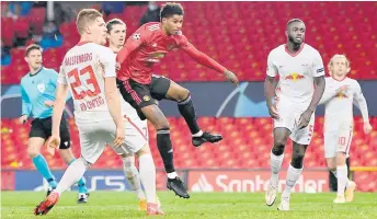  ?? — AFP photo ?? Manchester United’s Rashford (centre) watches the ball in to the net as he scores his team’s fifth goal, his third making a hat trick, during the UEFA Champions league group H match against RB Leipzig at Old Trafford stadium in Manchester, north west England.