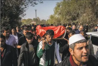  ?? Ivor Prickett / New York Times ?? Rovshen Iskandarov­a ( center) helps carry the coffin of his 7yearold daughter, Aysu, who was killed the day before in an Armenian rocket attack in the village of Qarayusifl­i, Azerbaijan.