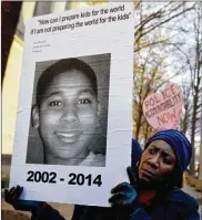  ?? ASSOCIATED PRESS ?? In this Dec. 1, 2014 photo, Tomiko Shine holds up a picture of Tamir Rice, the 12 year old fatally shot by a rookie police officer in Cleveland.