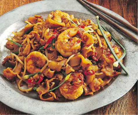  ?? PENNY DE LOS SANTOS ?? Penang’s famous char kway teow, a Malaysian street food favourite, relies on its broad cross-cultural medley of spices. Christina Arokiasamy’s latest cookbook pays homage to the flavours she remembers from her childhood experience­s on the Malaysian...