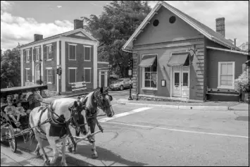  ?? DON PETERSEN / ASSOCIATED PRESS ?? Tourists pass the Red Hen restaurant, right, in Lexington, Va. White House press secretary Sarah Huckabee Sanders was refused service at the restaurant.