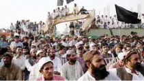  ?? - Reuters/Akhtar Soomro ?? ALLEGATION­S OF PERSECUTIO­N: People wave black flags as they gather to condemn the death of Naqibullah Mehsud, whose family said was killed by police in a so-called “encounter killing”, during a grand jirga (tribal assembly or public meeting) in...