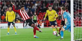  ?? — Reuters ?? Spot on: Sheffield United’s Lys Mousset scoring against Arsenal in the Premier League match at Bramall Lane on Monday.