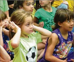  ?? PHOTOS BY MARY HUBER / BASTROP ADVERTISER ?? Bastrop kids enjoy a live performanc­e of the Texas A&M Chemistry Roadshow, which featured chemical reactions and loud explosions, June 7 at the Bastrop Public Library.