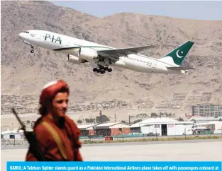 ?? — AFP ?? KABUL: A Taleban fighter stands guard as a Pakistan Internatio­nal Airlines plane takes off with passengers onboard at the airport in Kabul.