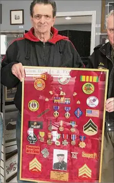  ?? Rev. Francis A. Kelley Military Society ?? Former Marine Sgt. Thomas Bain displays a shadow box that summarizes his exemplary military service.